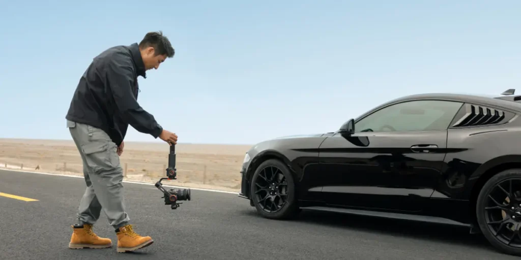 Videógrafo usando gimbal para lograr movimientos de cámara de cine grabando solo